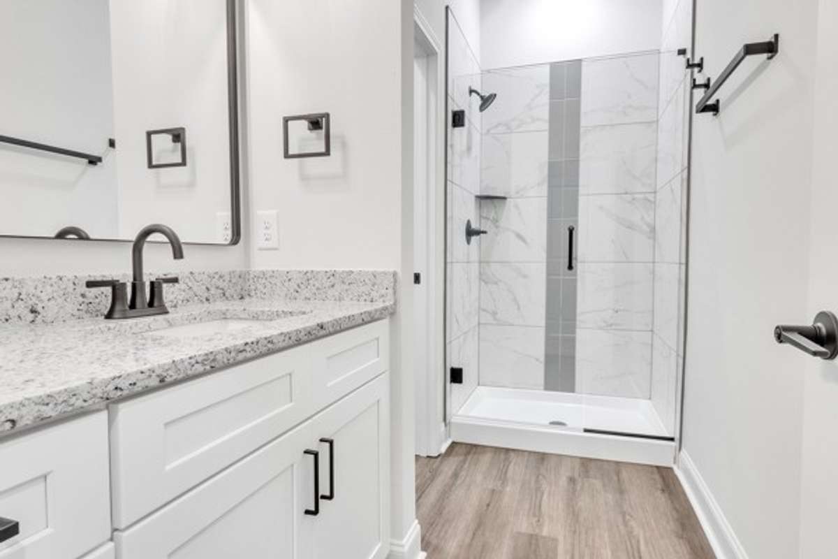 Spacious primary bath with granite, elegant tile and modern fixtures, decor & lighting. With the 10 ft ceilings and glass shower it has a true spa feeling!
