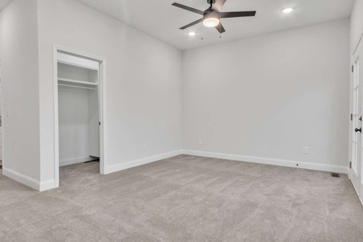 A shot back toward the entry and owner's closet featuring beautiful lighting and a modern fan & light.