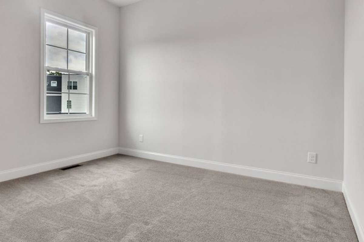 Guest bedroom just off the kitchen area with 10 ft ceiling, trendy ceiling fan and lighting.