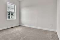 Guest bedroom just off the kitchen area with 10 ft ceiling, trendy ceiling fan and lighting.