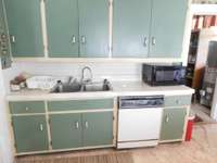 A peek into the larger laundry Room , back doorway to the covered porch