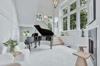 Grand Foyer features fireplace, marble floors curved staircase and lots of natural light.