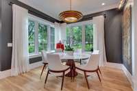 Dining Room features corner windows with treed views and hardwood floors