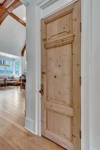 Coat closet features an antique pine door and hardware.
