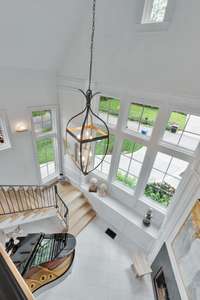 22 ft. Ceiling in Grand Foyer with gas fireplace, great natural  light and curved staircase.