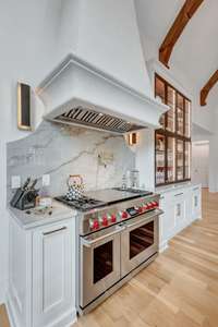Kitchen features 48 inch Wolf Stove, Wolf microwave and warming drawer, Sub Zero refrigerator and Fisher/Paykel dishwasher drawers plus a  dramatic custom vent hood.