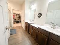 Double vanities, enclosed toilet, standing shower, linen closet, and walk-in closet