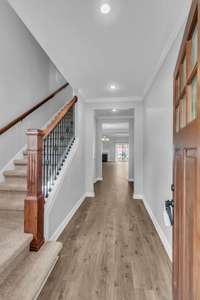 foyer with new lvp flooring and new carpet leading to secondary bedrooms.