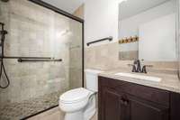 Full bath renovated with tile shower, tile floor, and granite top vanity