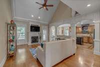 A family room with gorgeous hardwood and a vaulted ceiling.