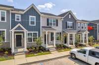 Landscaping is included! White brick townhome in the middle.