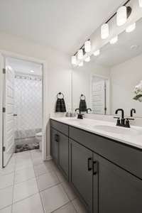 Upstairs hall bath with double sinks and separate shower and toilet room