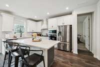 Gourmet Chef's Kitchen with wall oven, gas stove, white upgraded cabinets with quartz countertops.