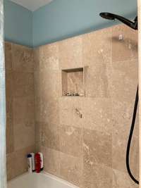 Guest bath features a tiled tub/shower combo.
