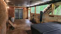 Covered patio with hot tub, which remains!  Double doors lead to finished basement den area.
