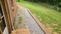 Stone walk way leads to side yard.  Door on left leads to covered patio.