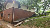 Side of home and HVAC system.  Fence extends to front corner of the home with a gate here too.