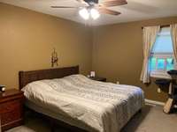 Primary bedroom with ceiling fan.