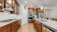 Upgraded kitchen featuring a gas stove with vented hood, built-in microwave and oven, large pantry, and an graded island perfect for meal prep and entertaining.