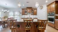 Upgraded kitchen featuring a gas stove with vented hood, built-in microwave and oven, large pantry, and an graded island perfect for meal prep and entertaining.
