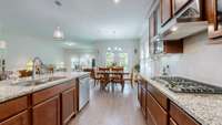 Upgraded kitchen featuring a gas stove with vented hood, built-in microwave and oven, large pantry, and an graded island perfect for meal prep and entertaining.