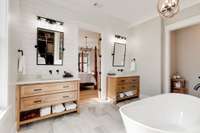 His and her vanities provide ample storage for both parties using this beautiful room!  You'll see a private "water closet" to the right with a space-saving pocket door.
