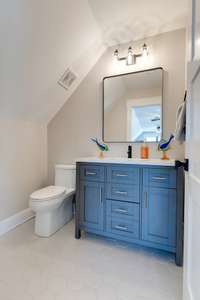 A chic blue vanity graces the upstairs powder room.