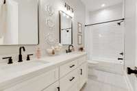 Even the secondary bath is well-appointed with stone surfacing and double sinks!