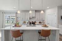 the large kitchen island has ample prep space and enough room for up to four dining places.