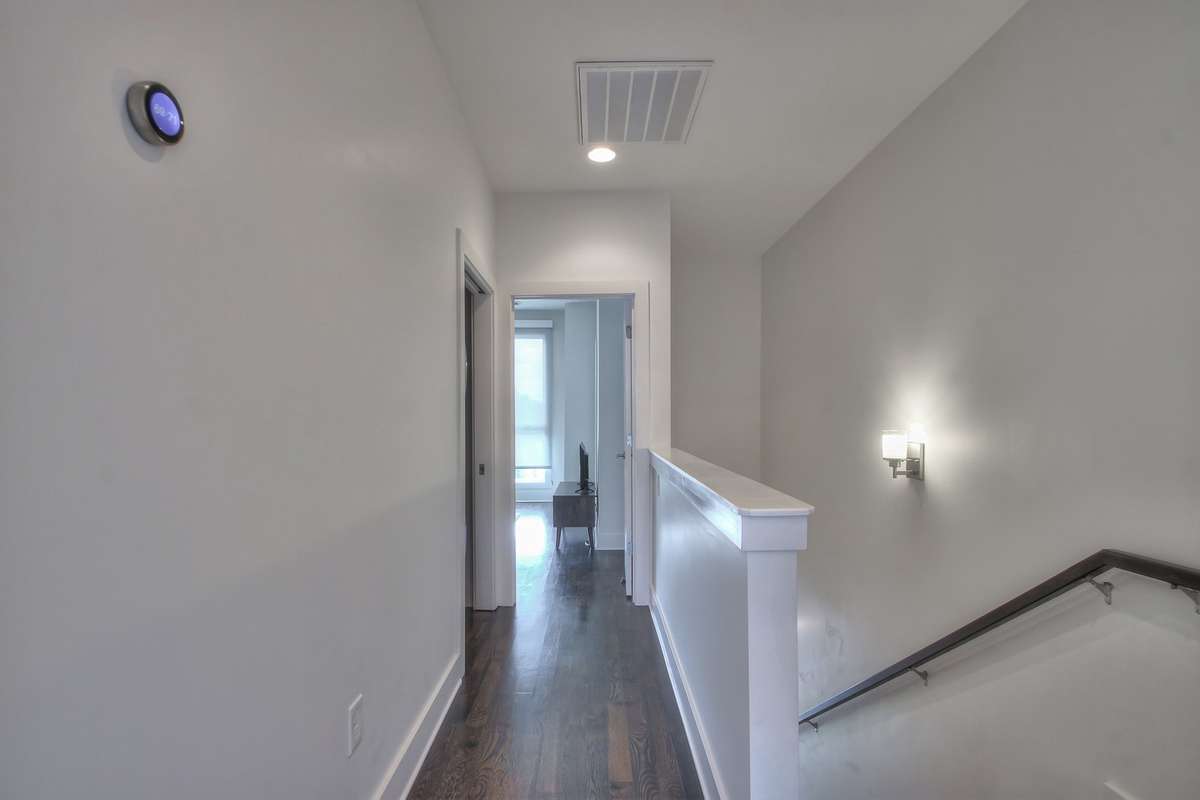 3rd floor hallway leading to another guest room and the laundry closet.