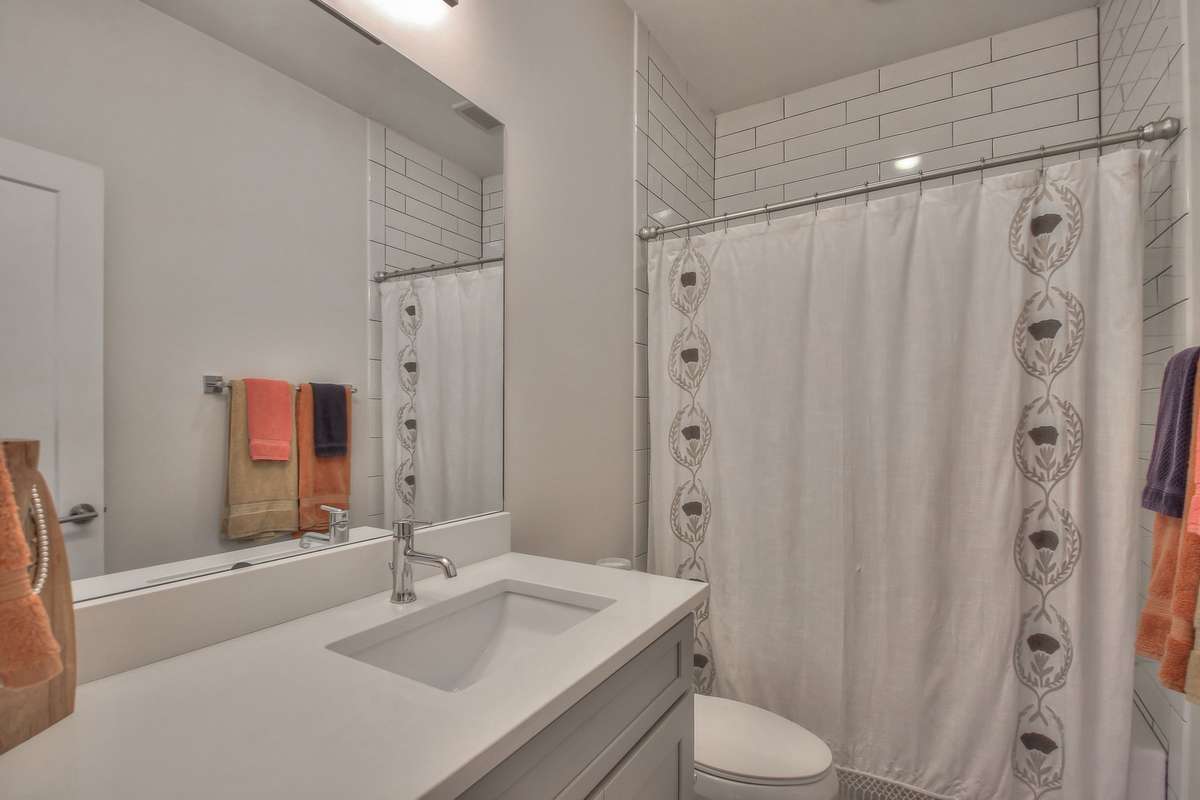 Guest room full bath with a tub/shower combo, updated tile, and modern finishes