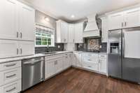Beautiful white cabinets, tile backsplash, and stainless steel appliances make this kitchen one that you want to cook in!