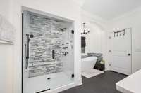 A view of the shower and tub in the primary bathroom.