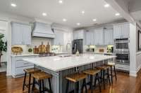Kitchen, showing the island with barstools and double ovens.