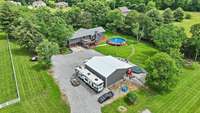 View from behind the garage, looking at the back of home. Show is 40x30 heated and cooled with a sink and toilet, car lift can remain. Sellers have brought tons of gravel in for extra parking. Shop has and can be used as mechanic shop.