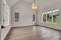 Second primary suite awaits upstairs with beautiful greenery views and vaulted ceilings!