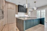This kitchen has it all! Double waterfall island, hidden pantry, double wolf ovens, 60" Wolf range, under island storage, matched paneled sub zero separate refrigerator and freezer.