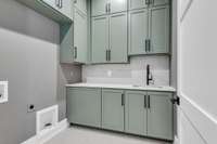 This home has two full sized laundry rooms. This one is on the main floor with a custom linen inspired wallpaper.