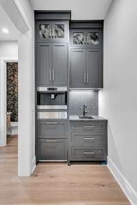 Surprises around every corner with this coffee bar that includes a Wolf built in coffee maker, refrigerator drawers, sink, and a warming drawer for your coffee mugs.