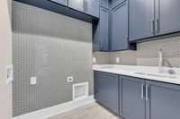 Second laundry fully built out with cabinets and soaking sink