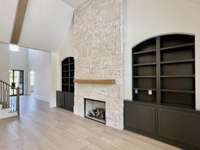 Surrounding the fireplace are built-in bookcases, elegantly crafted to seamlessly blend with the room's decor while providing a haven for literary treasures and cherished mementos.