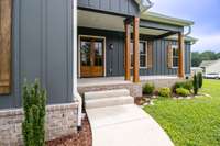 Fresh landscaping welcomes you to these gorgeous double front doors and cozy front porch!