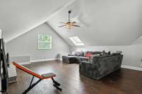 This spacious upstairs bonus room features skylights that flood the space with natural light and a cozy wood-burning fireplace for year-round comfort.