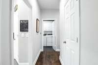 This well-planned hallway connects key spaces- with the kitchen to the left, powder room to the right, and laundry room straight ahead.