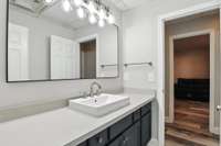This apartment bathroom features a sleek modern vanity, full bathtub, and updated lighting for a fresh, polished look.