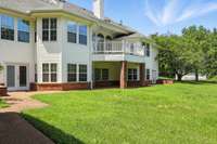 Looking at the back of the home, you'll see multiple levels of living space, a covered porch, and a private balcony - all surrounded by a park-like yard.
