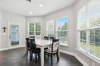Bright dining area with windows all around and direct access to the balcony.