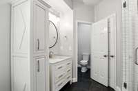 Enjoy the luxury of space with dual vanities and a second walk-in closet featuring custom wood shelving for organized, effortless living.