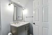 Upstairs bath with modern vanity and tub- simple, stylish, and practical.
