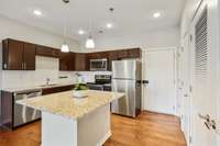 You'll love the granite countertops, stainless appliances, chrome fixtures, subway tile backsplash and pendant lighting above the contrasting island with seating. Wow!